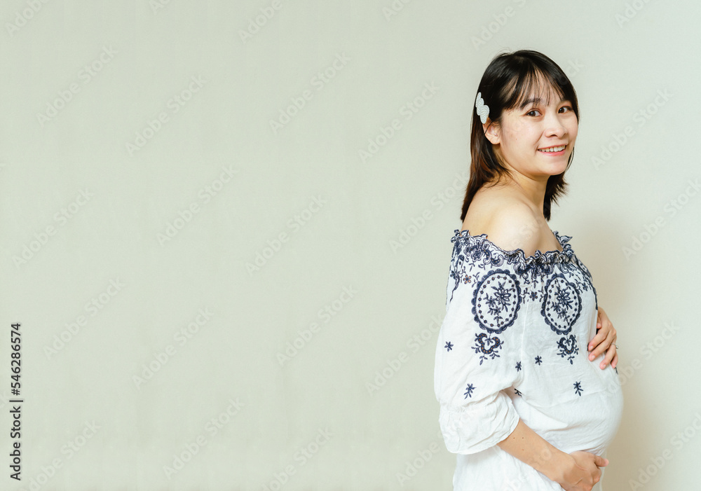 Pregnant happy woman touching her belly with a happy face, Caressing her belly and smiling, Healthy Pregnancy concept on white background, Copy space. Pregnant happy woman touching her belly with a happy face, Caressing her belly and smiling, Healthy Pregnancy concept on white background, Copy space.