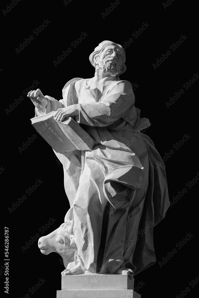 Ancient stone statue of Evangelist Saint Luke. Black and white image.