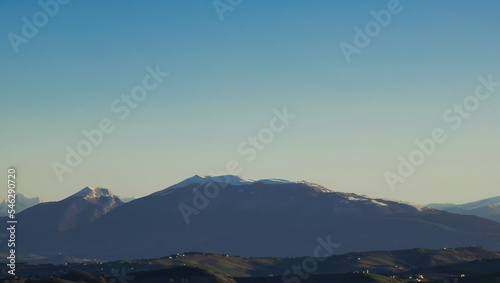 Monti Appennini innevati nel cielo azzuro di una giornata di sole invernale photo