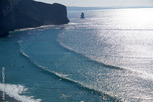surfers waiting for the perfect set of waves on praia da arrifana photo
