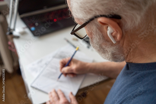 a male architect draws on a piece of paper, close-up of a hand with a pencil and a ruler