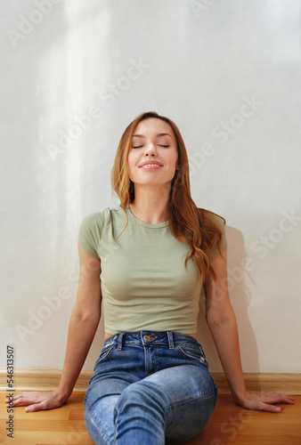 Smiling woman sitting against wall with scribbles