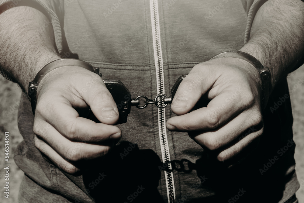 Handcuffed black and white photography. Law. Criminal in jail - obrazy, fototapety, plakaty 