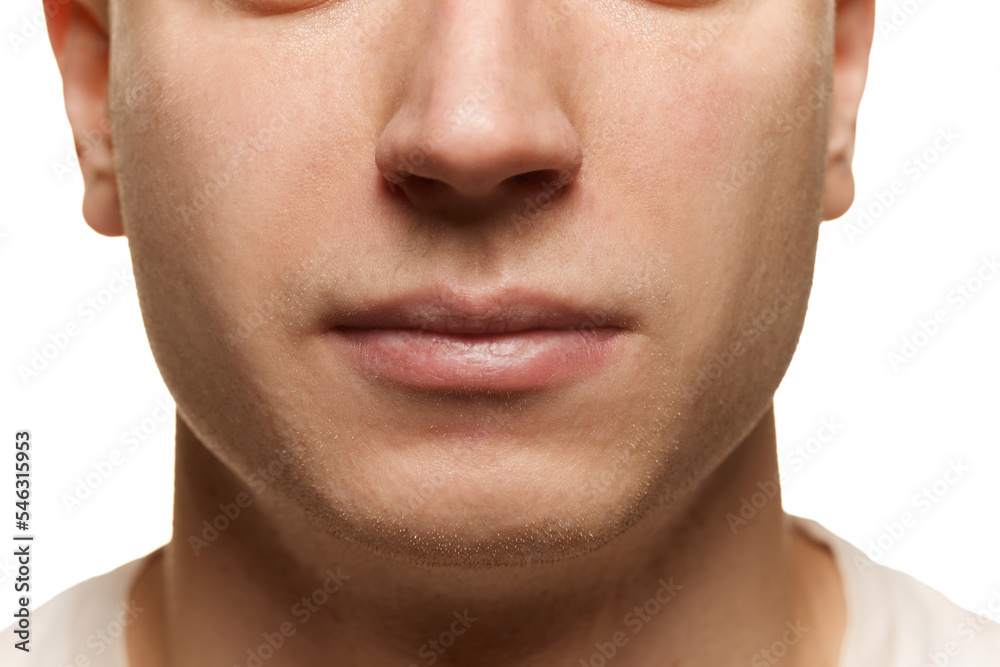 Obraz premium Close-up portrait of male face. Cropped image of nose and lips isolated over white studio background. Taking care after skin