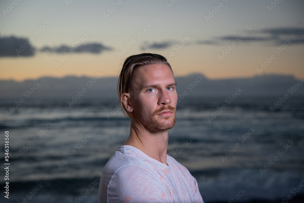 Portrait of an attractive caucasian boy at the beach during sunset.