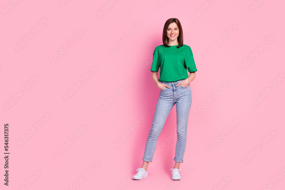 Full size photo of stunning young woman hold hands pockets new clothes promo dressed trendy green clothes isolated on pink color background Full size photo of stunning young woman hold hands pockets new clothes promo dressed trendy green clothes isolated on pink color background