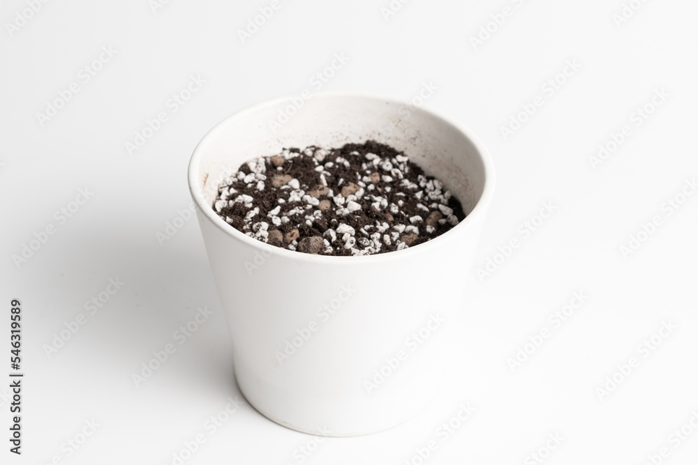 White ceramic pot with porous soil mixture in isolated white background. White ceramic pot with porous soil mixture in isolated white background.