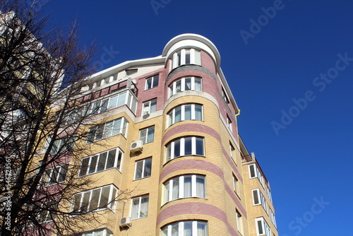 Multi-storey building with balconies against the sky on a sunny day.