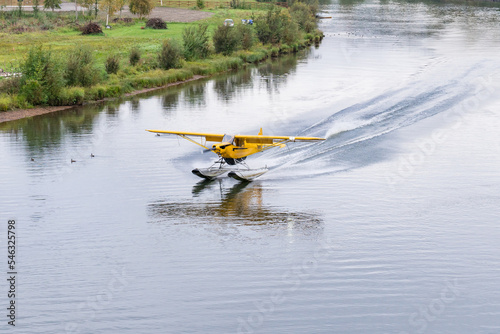 Bush float plane landing on  river in Alaska photo