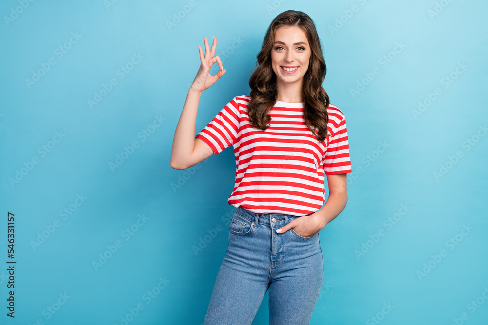 Photo of shiny pretty young girl dressed red outfit showing okey sign empty space isolated blue color background Photo of shiny pretty young girl dressed red outfit showing okey sign empty space isolated blue color background