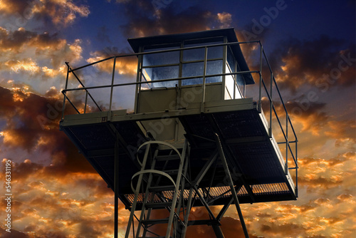 Metal structure of the watchtower, colorful sunset on the background