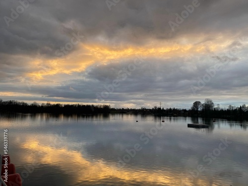 Beautiful fluffy cloudy sky at sunset reflecting on the lake water photo
