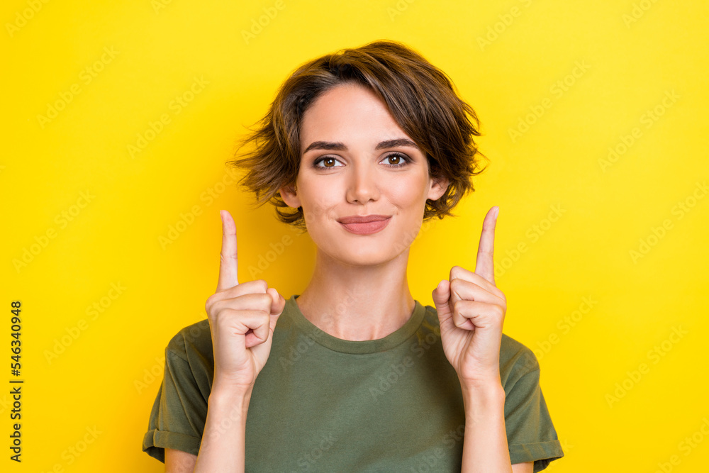 Portrait of adorable optimistic woman with bob hairdo dressed khaki t-shirt directing empty space isolated on yellow color background Portrait of adorable optimistic woman with bob hairdo dressed khaki t-shirt directing empty space isolated on yellow color background