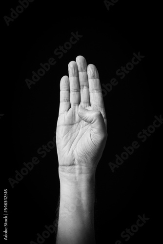 Hand demonstrating the Arabic sign language letter 'ك' or 'Kaf'