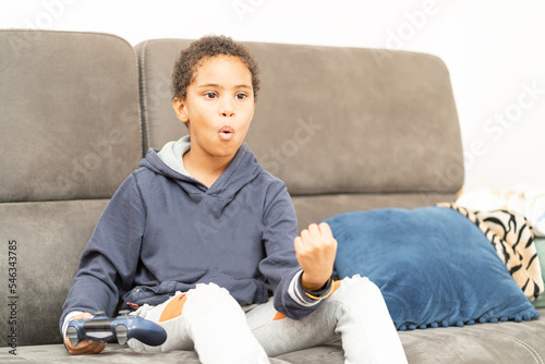 giovane adolescente che sulla giocando ad un gioco sul computer photo
