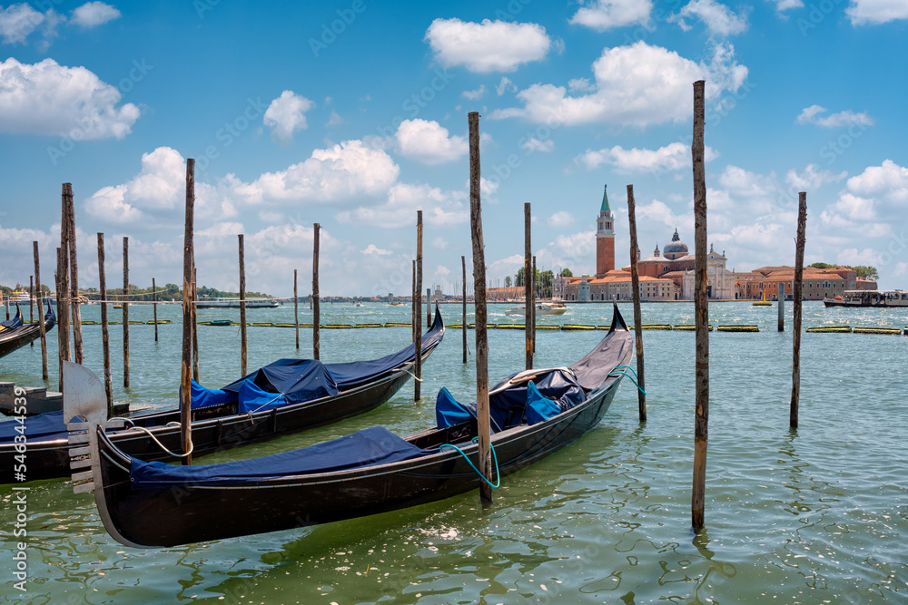 Close-up of a gondola and a series of Venetian gondolas with no one on board.