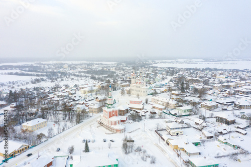 Panorama of a small city in the depths of Russia from a height. Orthodox churches and traditional old wooden houses, Totma in the Vologda region and a winter view of the city