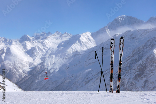 Skis stand in the snow against the background of beautiful snow-capped mountains