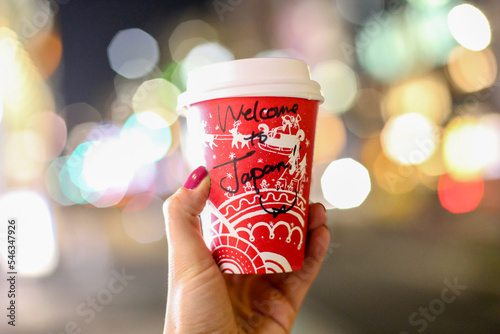 Kubek z kawą na tle świateł miasta © Aleksandra