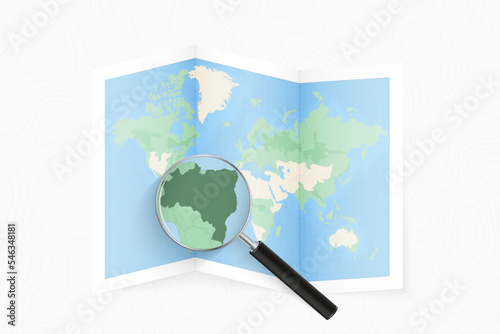 Enlarge Brazil with a magnifying glass on a folded map of the world.