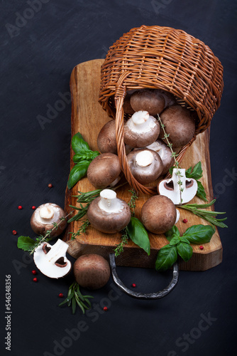 Fresh champignon mushrooms on dark wooden table