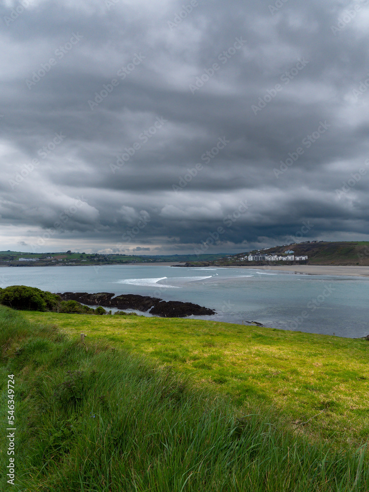View of Clonakilty Bay. Thick grass. The coastline of the Ireland. Seaside landscape. Cloudy weather before a thunderstorm. View of Clonakilty Bay. Thick grass. The coastline of the Ireland. Seaside landscape. Cloudy weather before a thunderstorm.
