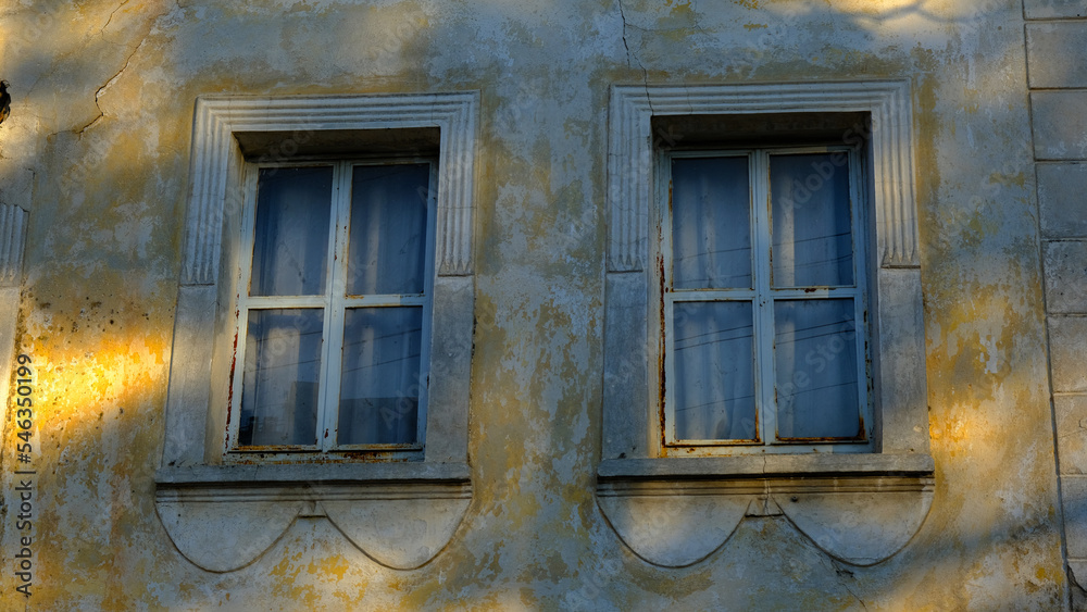 Obraz premium Windows of an old house with yellow walls