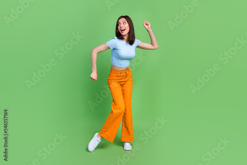 Full length portrait of excited satisfied person dancing partying spend free time isolated on green color background © deagreez