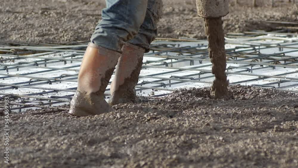 Worker pouring concrete mix on a concreting formwork. Forming an