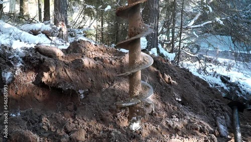 Drilling cold winter ground in a forest. Clip. Industrial background, construction site in the countryside. photo