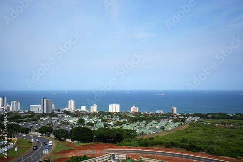 Durban, Umhlanga beach front top view over the business district with the Indian ocean in view with Ships on the water waiting to dock and unload. Stunning blue sky with a few wafts of cloud hanging 