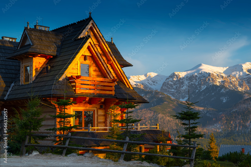 Obraz premium evening beautiful wooden house standing high in the mountains