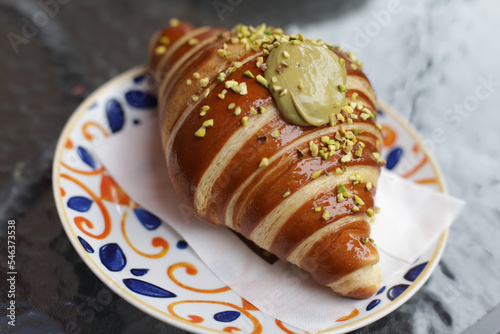 Big tasty and delicious croissant with pistachio cream filling on plate