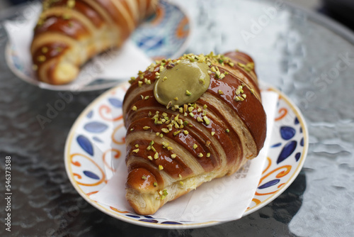 Big tasty and delicious croissant with pistachio cream filling on plate