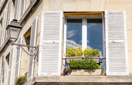 Photography Traditional shuttered window with window box and traditional street light, Paris