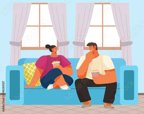 Communication at home. Man and girl sitting in apartment in comfort couch eating popcorn talking. Evening romantic dinner, family conversation. People with tasty food in house, married couple