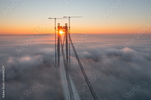 Panoramic aerial drone view from above of the suspended bridge over danube river, under construction, between Braila and Tulcea cities in Romania photo