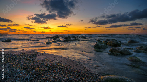 Wonderful orange sunset on the rocky coast of the sea