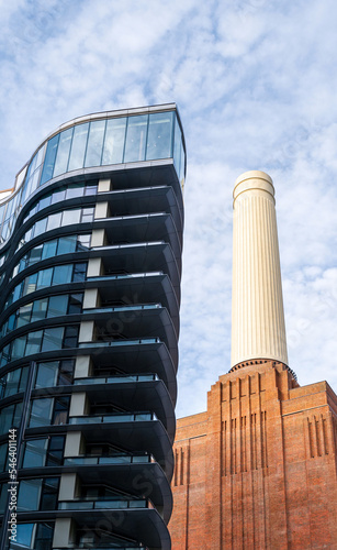 Low angle view at chimneys and brick facade of iconic London landmark Battersea Power Station and surrounding area.