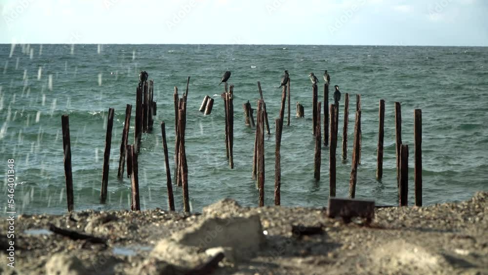 Old ruined sea pier, rusty piers sticking out of the water Old ruined sea pier, rusty piers sticking out of the water