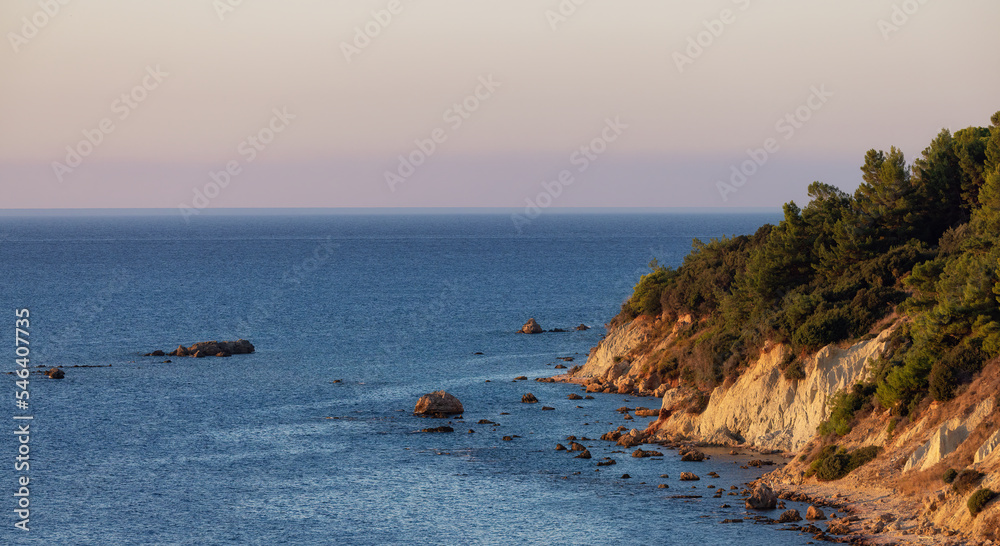 Rocky Coast on Ionian Sea in a small touristic Town. Katakolo, Greece. Sunny Sunrise Sky.