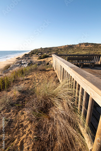 One of the most beautiful beaches in Spain, called (Cuesta Maneli, Huelva) in Spain.  Surrounded by dunes, vegetation and cliffs.  A gorgeous beach. photo