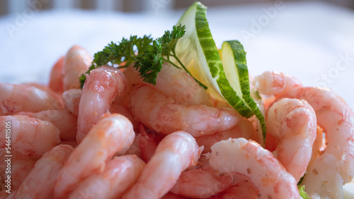 Close up of peeled fresh shrimps on white bread, making a delicious Swedish shrimp sandwich (räkmacka).
Seafood and food preparation concept.