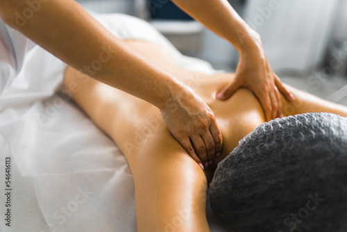 Stress reducing massage. Relaxing back massage performed by professional unrecognizable caucasian massage therapist. Blurred background. High quality photo