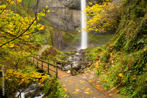 Latorell Falls, Columbis River Gorge National Scenic area in the autumn season with leaves showing fall color.  Bridge over Latorell Creek in foreground. photo