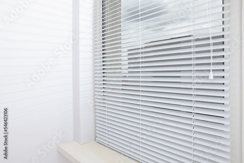 Stylish window with horizontal blinds in room © New Africa