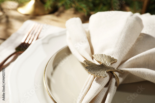 White fabric napkin with beautiful decorative ring for table setting on plate, closeup © New Africa
