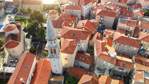 Panoramic sunset aerial drone view of ancient city of Budva, Montenegro. Old medieval town with red roofs. Kotor bay, coast of Adriatic sea. Budva is most popular resort town in Montenegro