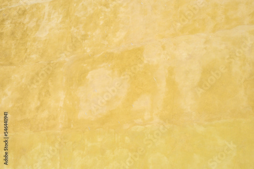 Textured wall in shades of yellow paint, as a graphic background 