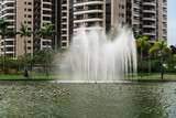 Park with buildings and a large green area in the midst of nature and the dance of water in the fountain of the lake
